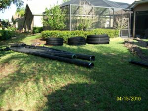 Materials laid out while trench is dug for the drain, which will eliminate standing water on the pool deck.