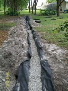 In process of turning into a French drain - eco fabric and bedding gravel going in.